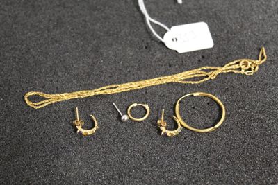 beaucoup de bijoux en or par terre, à côté d'une étiquette