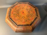 an old wooden box sitting on top of a table next to a cup