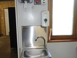 un lavabo et une poubelle dans un coin de la pièce