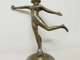 une image représentant une statue en bronze d'une femme tenant une balle