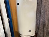un chauffe-eau blanc posé sur un support dans une pièce