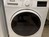 une machine à laver et un sèche-linge posés l'un à côté de l'autre sur le sol