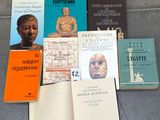 Plusieurs livres sont posés par terre, les uns à côté des autres.