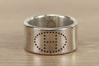 a close up of a silver ring on a wooden table