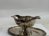 a silver plate with a saucer and a spoon on it