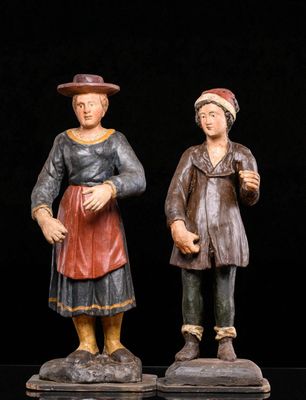 two figurines of a man and a woman standing next to each other