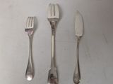three forks and a knife are sitting on a white surface