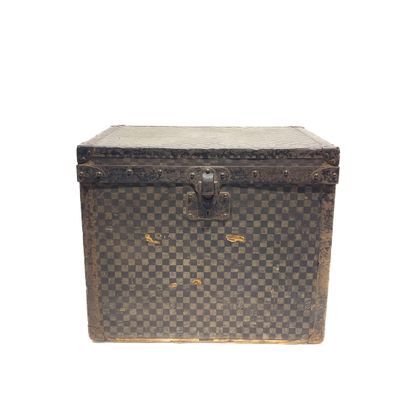 une vieille malle ornée d'un motif à carreaux