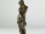 une statue en bronze représentant une femme tenant un vase