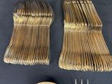 many forks and spoons laid out on a table