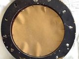 a picture of a black and gold plate on a white sheet