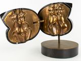 a gold sculpture of a woman and a man on a stand