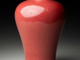 a red vase that is sitting on a table