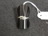 une bague en argent sertie d'une pierre bleue, à côté d'une étiquette de prix
