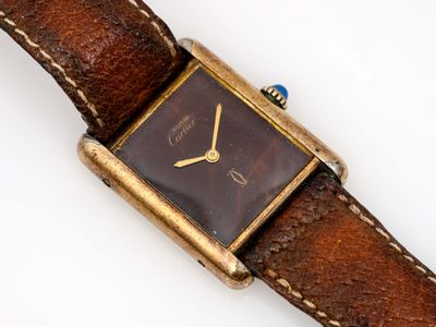 une montre posée sur un bracelet marron