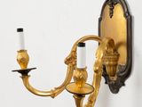 a wall mounted candle holder with two candles on it