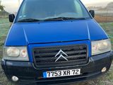 La camionnette bleue est garée sur l'herbe, dans le champ.