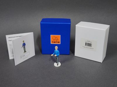 La figurine est assise à côté d'une boîte de cartes et d'une carte