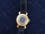 a close up of a wrist watch on a blue cloth