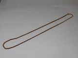 an image of a gold necklace with a chain on a white surface