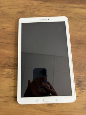 Quelqu'un prend une photo de son téléphone portable posé sur une table en bois.