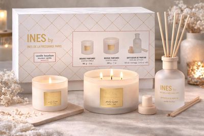 a white box with three candles and a candle holder next to it