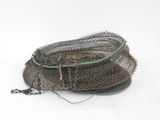 un panier surmonté d'un filet de pêche, posé sur une surface blanche