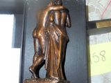 une statue en bronze représentant un homme et une femme, posée sur une plaque