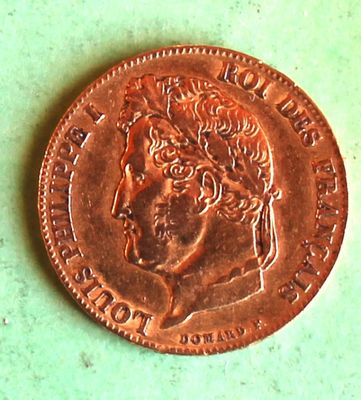 a close up of a penny on a table with a green background