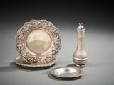 un plateau en argent et un vase en argent posés sur une table