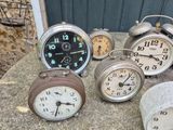 many clocks that are sitting on a table outside