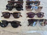 several pairs of sunglasses sitting on a table with a price tag