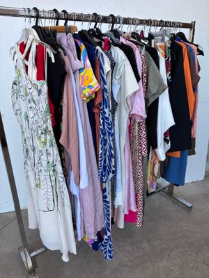 beaucoup de vêtements suspendus à une étagère dans une pièce