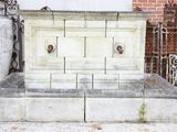 une fontaine en pierre située devant un bâtiment en briques