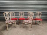 four chairs with red cushions in front of a garage door