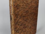 an old book sitting on top of a white surface