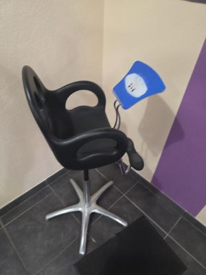 une chaise noire sur laquelle est posée une lumière bleue, dans une pièce