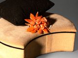 a black and orange flower sitting on top of a wooden box