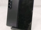 a close up of a cell phone on a stand on a white surface