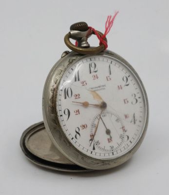 a silver pocket watch with a red string on it