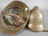 a metal helmet and a metal bowl on a table