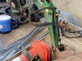 a tractor that is parked next to a pile of construction equipment
