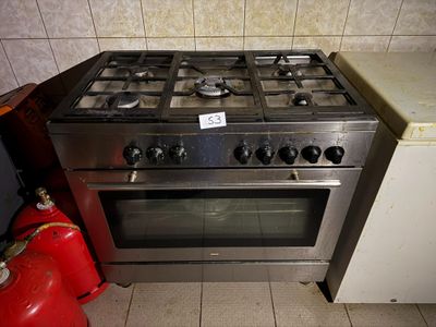 un poêle argenté avec une borne d'incendie rouge à côté