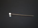 un gros plan d'une aiguille sur laquelle est fixée une boule blanche