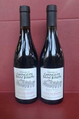 deux bouteilles de vin posées sur une table l'une à côté de l'autre