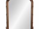un grand miroir décoré, doté d'un cadre en bois orné de sculptures élaborées