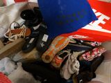 a pile of clothes and shoes on a bed