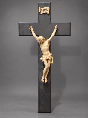 une statue de Jésus sur la croix, avec une pancarte sur laquelle est écrit « Jésus »