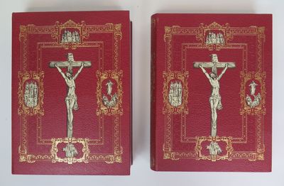 two red books with gold trim and a crucifix on them