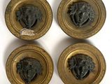 quatre plaques en laiton vieilli représentant une tête d'homme et une tête de femme